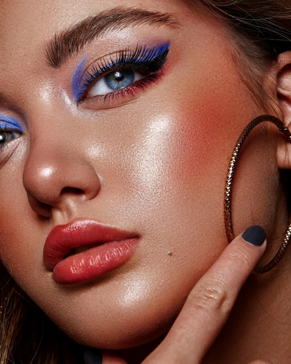 a close up of a woman with blue eyeliners and make - up