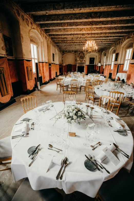 a room full of tables with plates and silverware