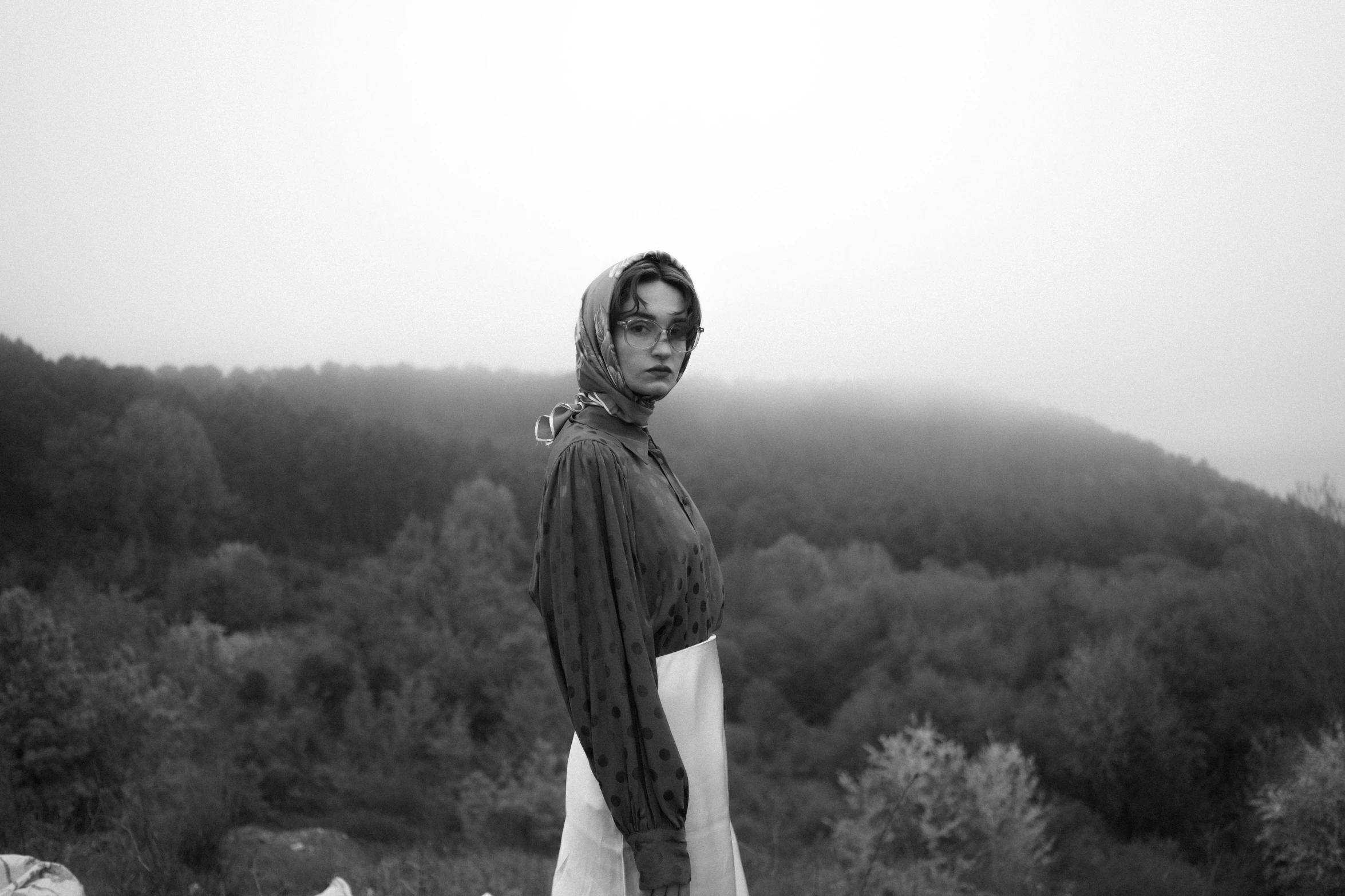 a young man is standing outside and wearing a scarf