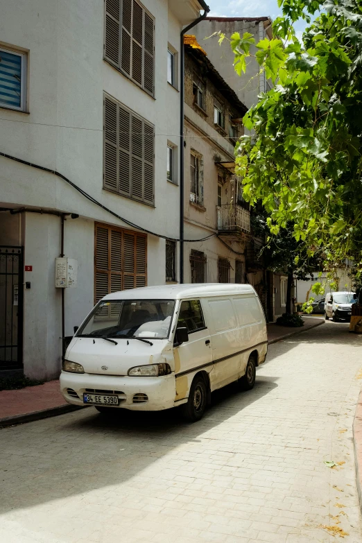 a small white van parked next to a large building