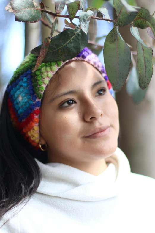 a woman wearing a multicolored crocheted hat