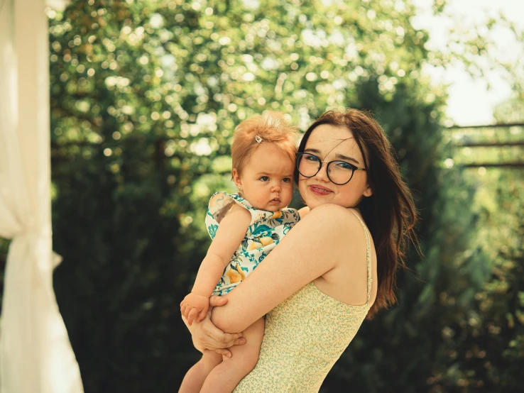 a woman holding a baby on her arms