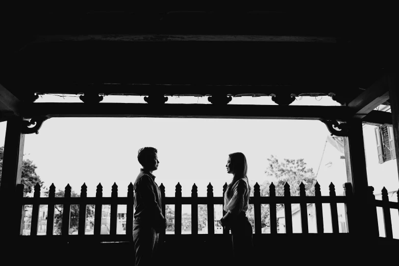 two people are walking underneath a pavilion at the park