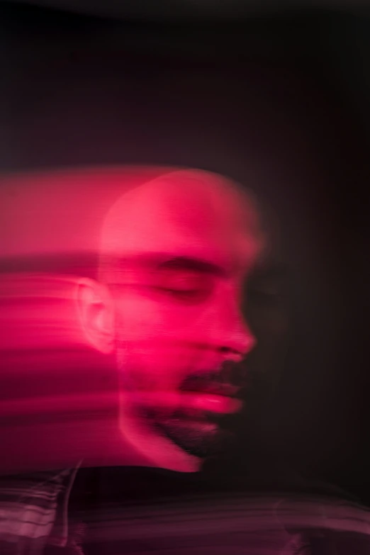 blurry image of a face of a man with a dark background