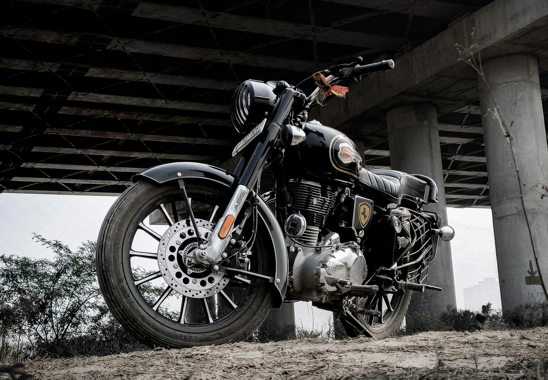 a black motorcycle is under a very large bridge