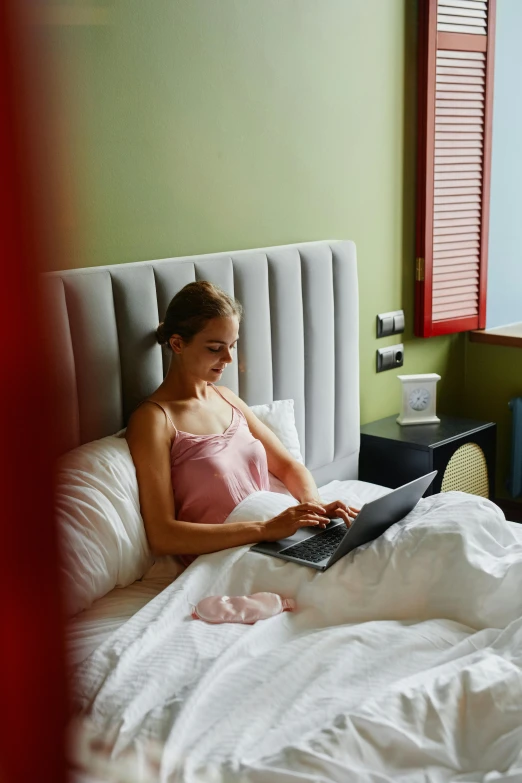 a woman sitting in bed with a laptop