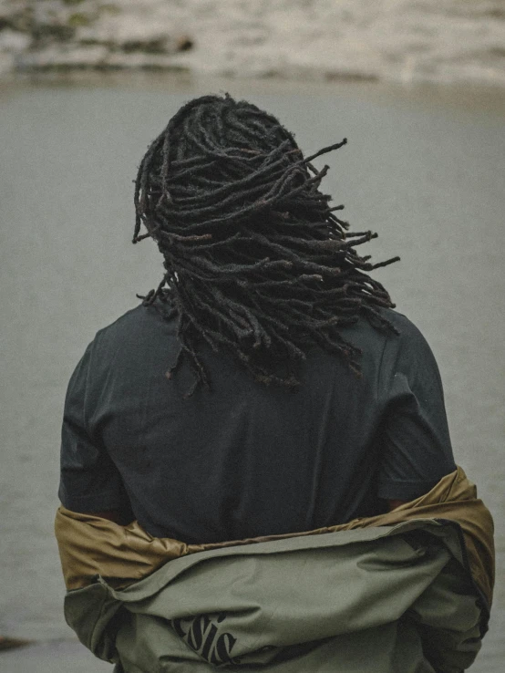 a man with dreadlocks walking in a wet area