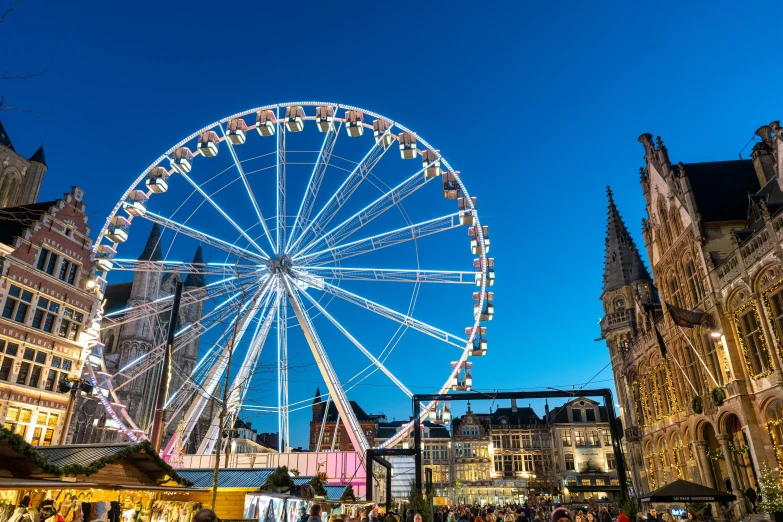 an outdoor fair in the city with a ferris wheel