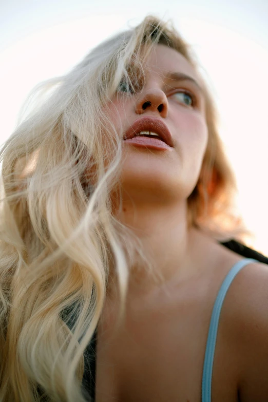 a blonde haired lady is posing with her hair blowing