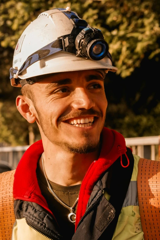 a man wearing a hard hat smiles for the camera