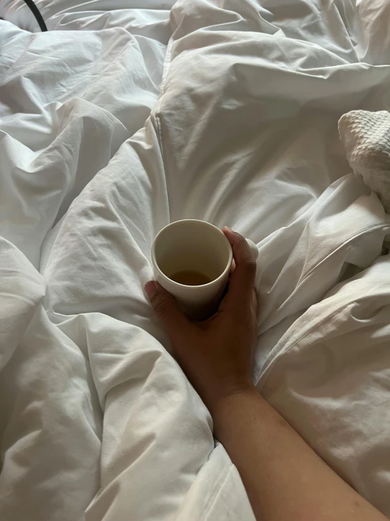 someone holds their hand next to a cup of coffee