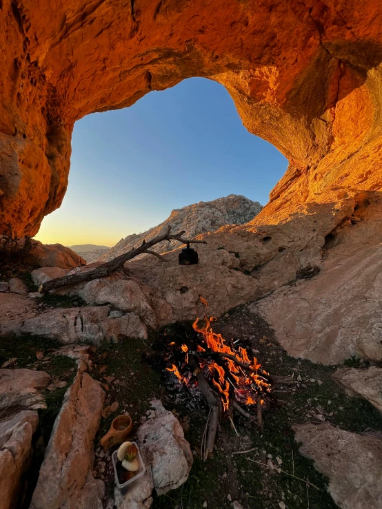 an outdoor fire pit near a rocky cliff