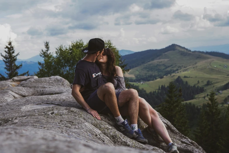 a couple that is sitting on a rock