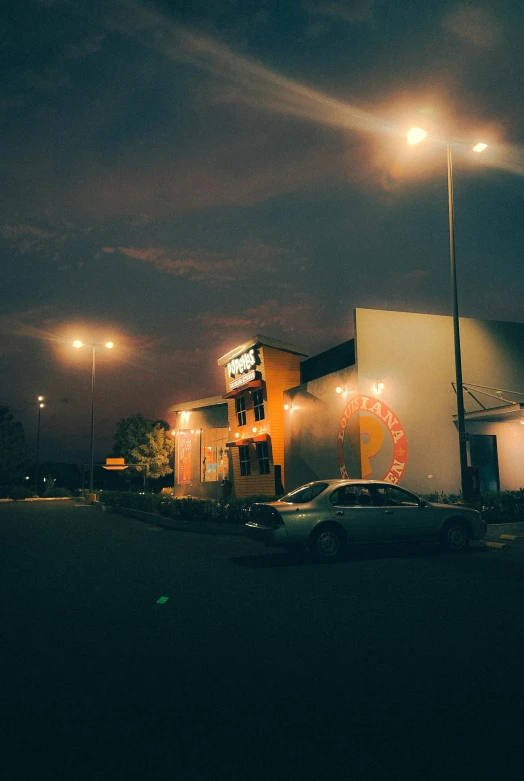 an empty parking lot in front of a night time business