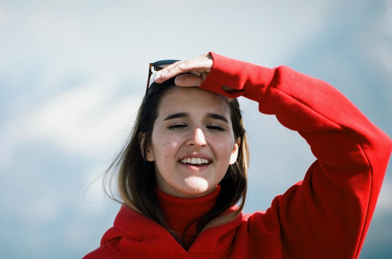 a woman smiling holding her head to her hair