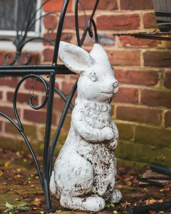 the small white rabbit statue is by the pole