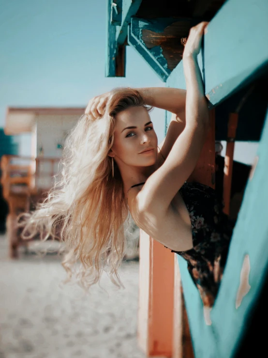 a beautiful young woman standing next to the beach