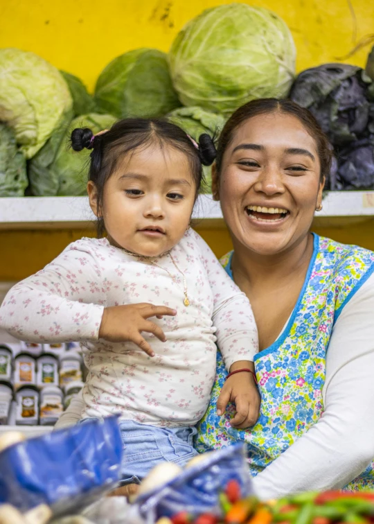 a women and child are at a stand in a market