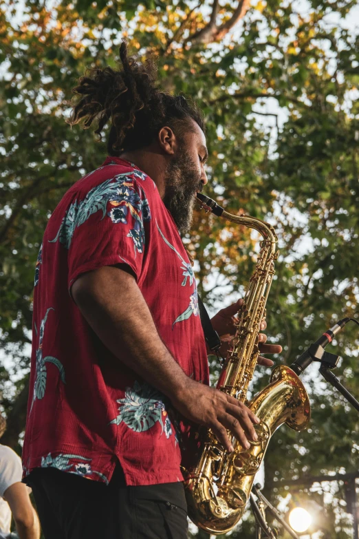 man playing saxophone in front of people watching