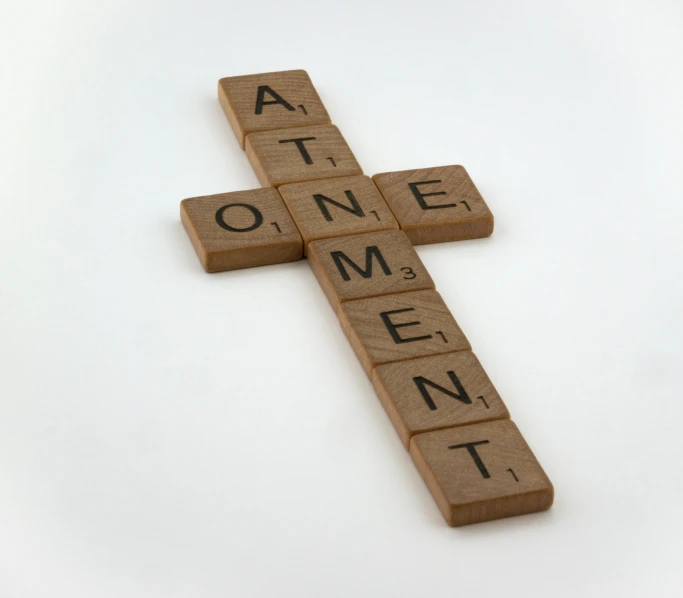 a cross made from wooden blocks has the word art one - word spelled in small letters
