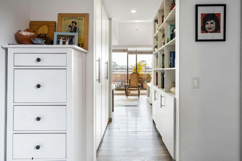 a hallway with a shelf and a chest of drawers