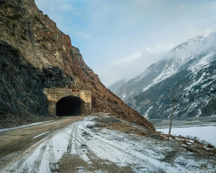 a road in front of a snow - covered mountain