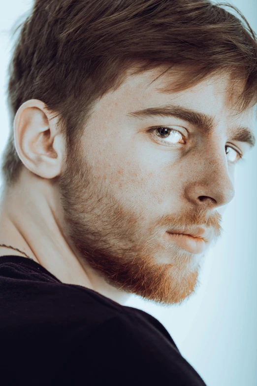 man with beard looking intently at camera while wearing black shirt