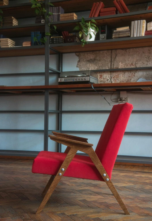 a red chair is sitting in front of a bookshelf