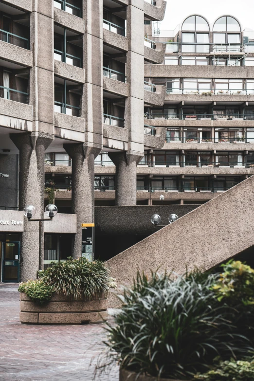 a stone building that has a bunch of plants near it