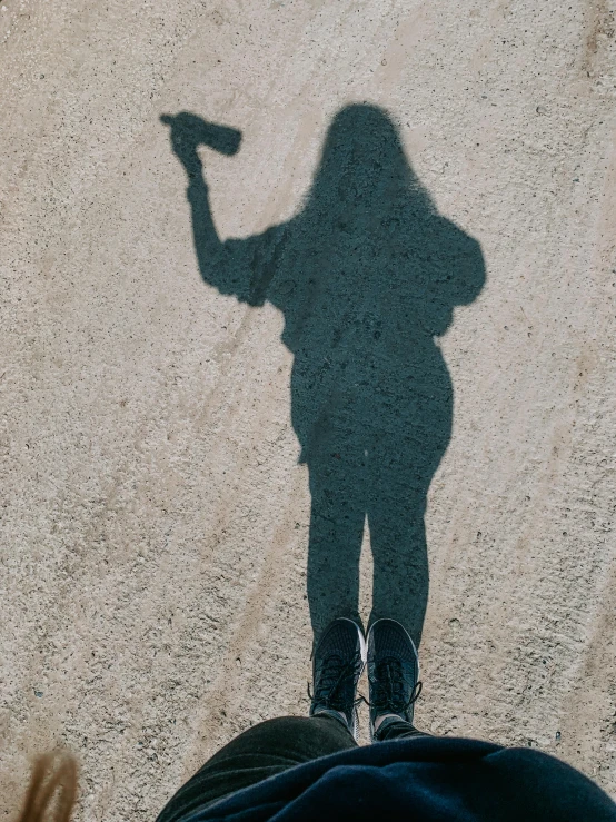 a shadow of someone holding an object in their hand