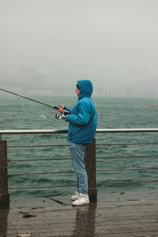 a man fishing from the side of a boat in the ocean