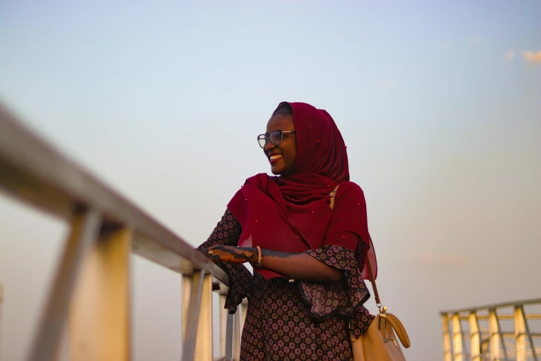 a young woman wearing a scarf and reading soing