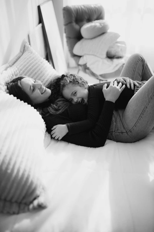 two women laying on the floor smiling at each other