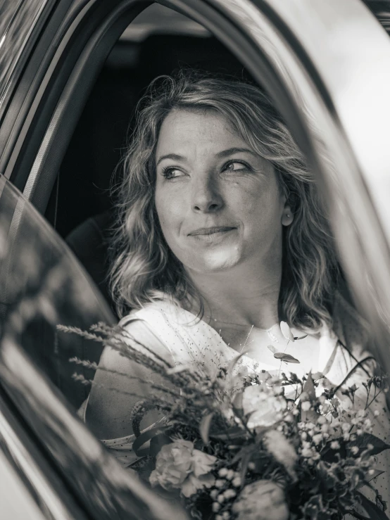 woman smiling while sitting in car looking out the window