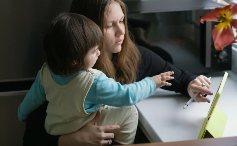 mother and child at a counter looking at an appliance