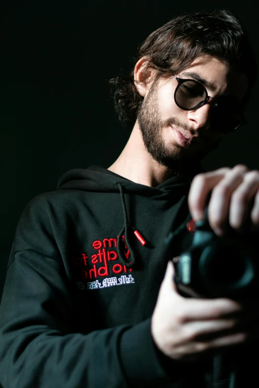 a man with long hair and a beard wearing sunglasses holding a camera