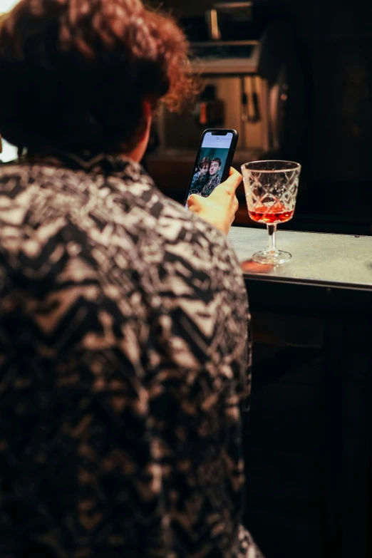 a person sitting at a bar using a cell phone