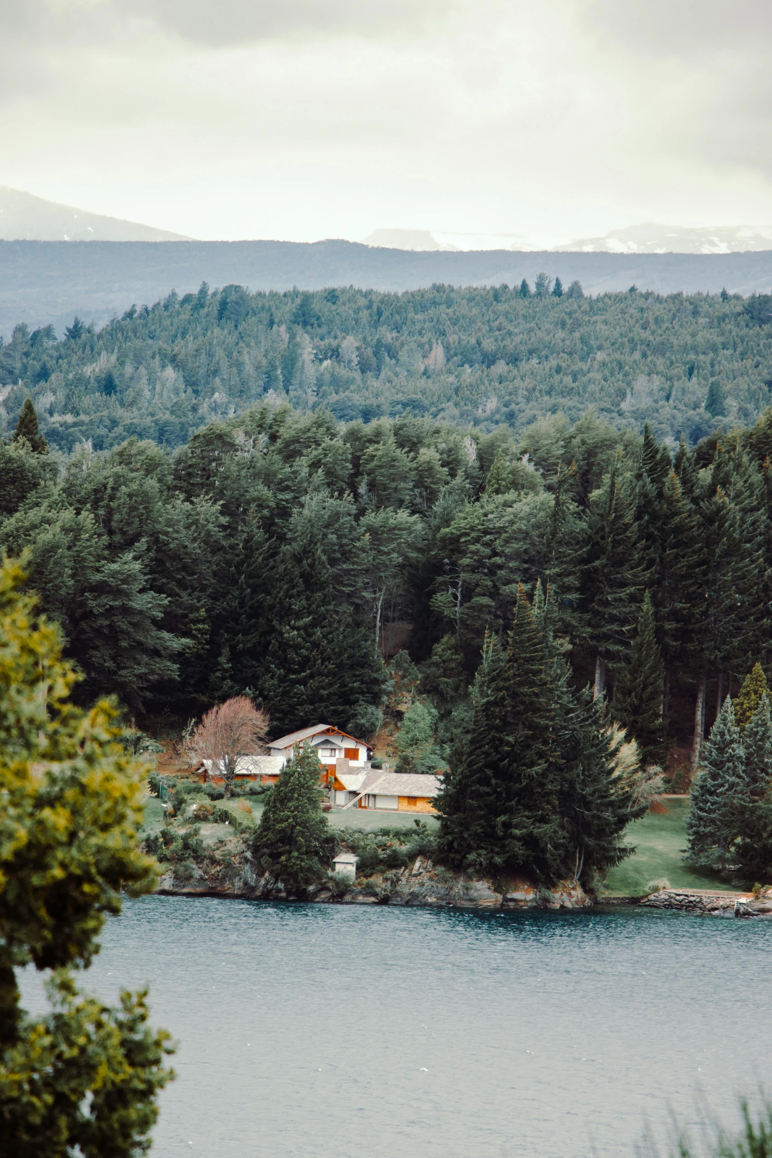 an island with mountains and a house in the distance