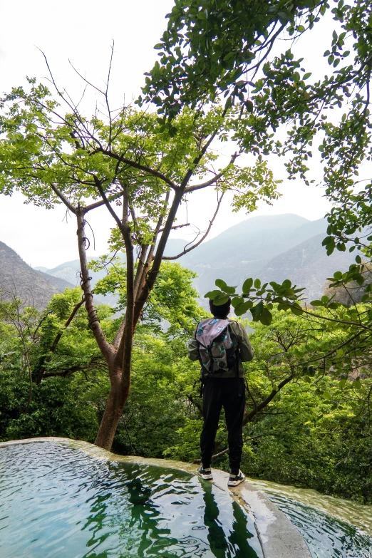 the man is looking at the mountains as they take a drink