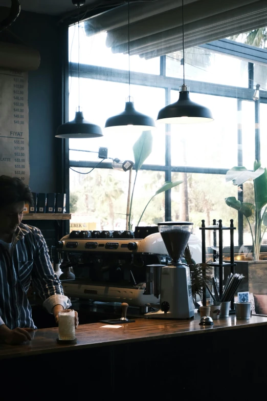 a man in a restaurant drinking a coffee machine