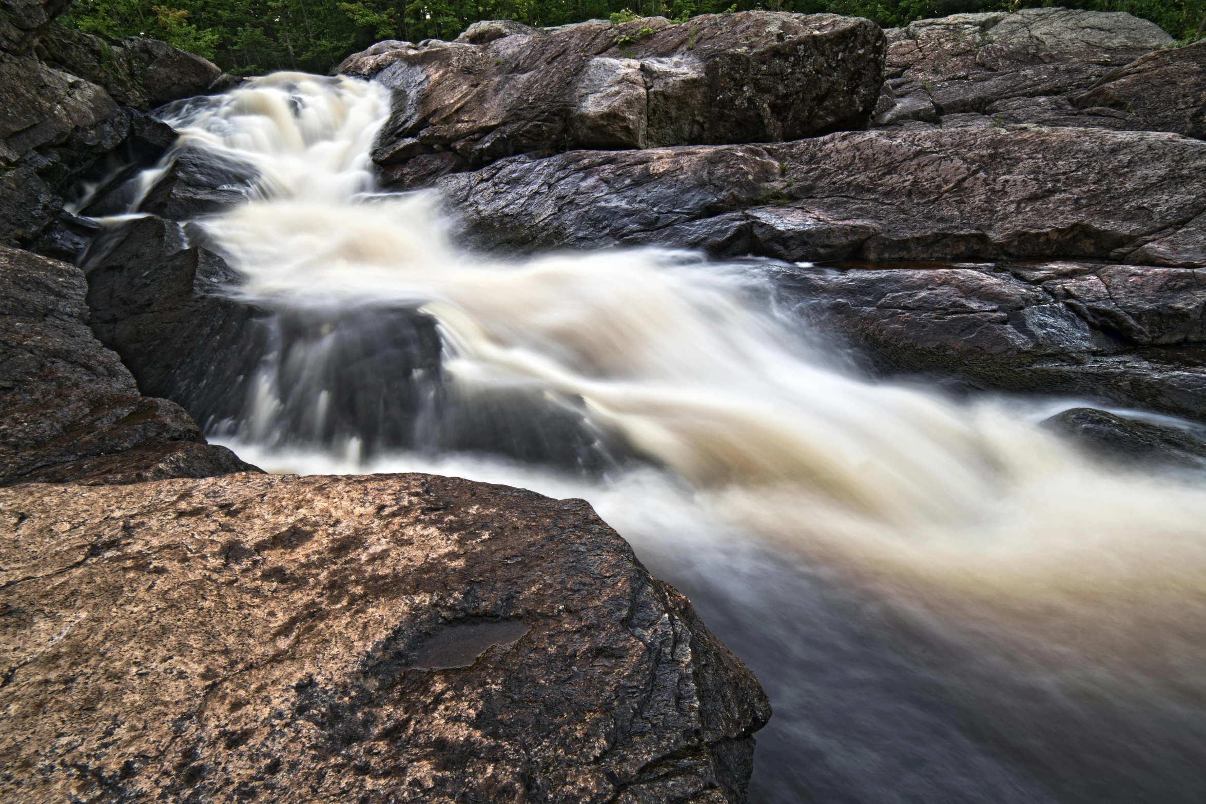 there is a large waterfall that runs through the rocks