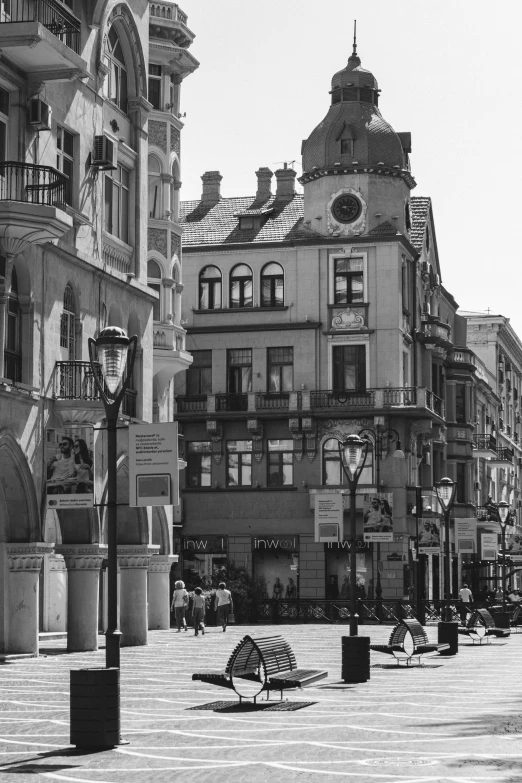 an empty street has a row of buildings and lots of people