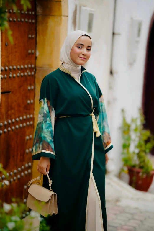 a woman standing outside in a green robe and head wrap