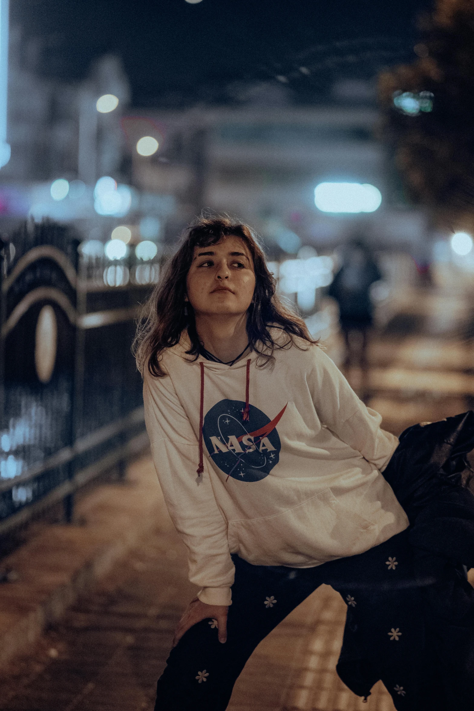 a woman sitting on top of a metal fence