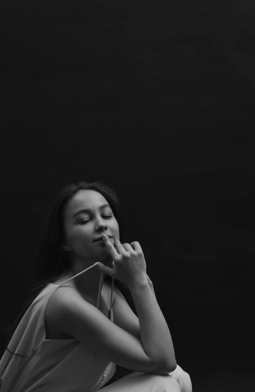 a woman sitting down with her face closed in a praying pose