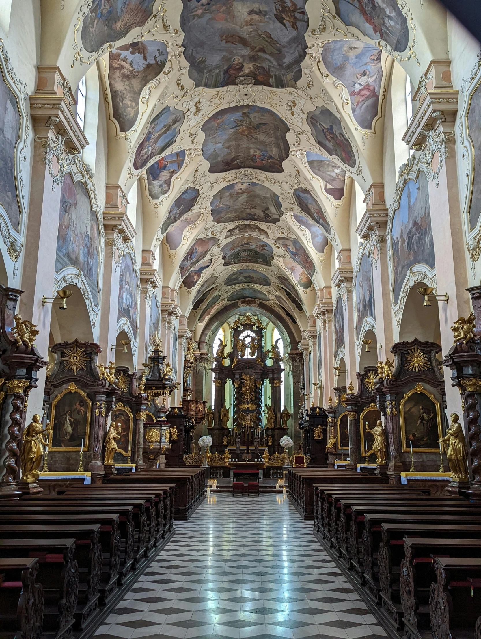 a picture of a cathedral with paintings hanging in the ceiling