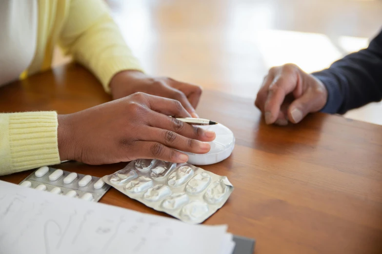 two people with a pills pill box and a remote