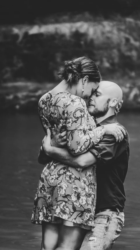 a couple hug while posing in the water