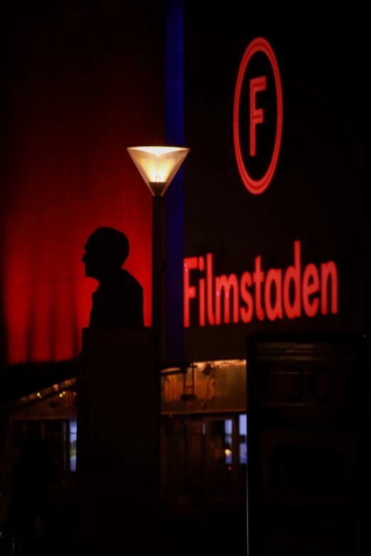 a man is standing in front of a sign that says filmstation