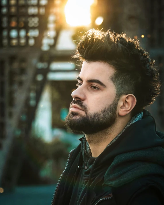 a man with his hair in bun up is looking off to the side